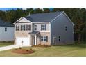 Two-story home showing a brick and siding facade with a well-maintained lawn and landscaping at 633 Kimberwick Dr, Locust Grove, GA 30248