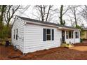 Exterior view of a cozy home with white siding, blue shutters and door, and a well-maintained lawn at 3601 Orchard Cir, Decatur, GA 30032