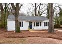 Cozy home exterior showcasing a blue door, white siding, black shutters, and a lawn covered in pine straw at 3601 Orchard Cir, Decatur, GA 30032