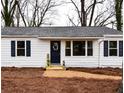 Quaint home featuring white siding, dark shutters, and a welcoming entrance with seasonal floral decorations and tidy landscaping at 3601 Orchard Cir, Decatur, GA 30032