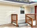 Close-up of the home's porch, showcasing the wooden railing, steps, and the home's light-colored siding and brick accents at 2182 Rosewood Rd, Decatur, GA 30032