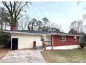 Exterior shot showcases the home's light siding, red brick accent, gray roof, and a small wooden porch at 2182 Rosewood Rd, Decatur, GA 30032