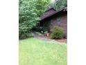 Exterior shot of home showing mature trees, brown siding, and a pathway to the entrance at 3315 Canterbury Trl, Rex, GA 30273