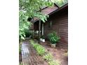 Exterior shot of home showing brown siding, manicured landscaping, and a brick walkway to the entrance at 3315 Canterbury Trl, Rex, GA 30273