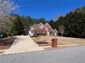 Lovely brick two-story home with a long drive and mature trees in the background at 3650 Burnt Hickory Dr, Dacula, GA 30019