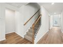 An interior view of a carpeted staircase with wood and wrought iron balusters and wood-look flooring at 3954 Brushy St, Powder Springs, GA 30127