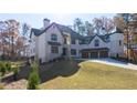 Elegant white brick home on a sprawling green lawn with mature trees at 10745 Shallowford Rd, Roswell, GA 30075