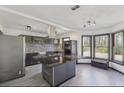 Modern kitchen with stainless steel appliances, dark countertops, and an island cooktop with range hood at 1310 Dillon Rd, Austell, GA 30168