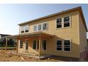 Back exterior of a two story house with wooden siding and windows and an unfinished patio at 206 Wild Ginger Bend, Woodstock, GA 30188