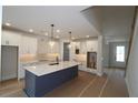 Modern kitchen with a large island, white cabinets, and sleek pendant lighting at 206 Wild Ginger Bend, Woodstock, GA 30188