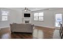 Spacious living room featuring a fireplace, large windows, and hardwood floors at 8605 Gladden Ln, Suwanee, GA 30024
