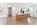 Bright kitchen featuring a center island, white cabinets, stainless appliances, and wood-look flooring at 2719 Byess Ct, Marietta, GA 30064