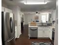 Bright and airy kitchen with white cabinets and stainless steel appliances overlooking the living room at 3571 Parc Sw Cir, Atlanta, GA 30311