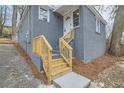 Exterior view of a gray brick house with newly-built wooden entrance stairway and white door trim at 403 Westchester Nw Blvd, Atlanta, GA 30314