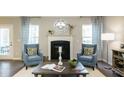 Comfortable living room with two blue armchairs, fireplace, decorative mirror and coffee table with white rug at 524 Lanier Way, Temple, GA 30179