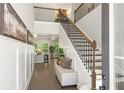 Bright foyer with high ceilings, a staircase with dark wood and metal railings, and a bench seat at 897 Porches Way, Dacula, GA 30019