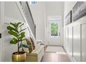 Inviting foyer with bench seat, a large houseplant, a patterned rug, and a windowed front door at 897 Porches Way, Dacula, GA 30019