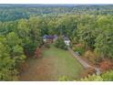 Expansive aerial view of a home nestled among lush, mature trees and a well-kept lawn and driveway at 6791 Yacht Club Dr, Acworth, GA 30102