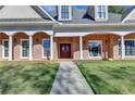 Elegant brick facade with a covered entrance and well-maintained lawn, creating a welcoming approach at 6000 E Andechs Smt, Johns Creek, GA 30097
