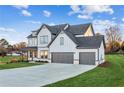 Home featuring a manicured lawn and a three-car garage, grey and white siding, and covered porch at 2759 Porches Ln, Dacula, GA 30019