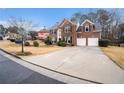 Spacious brick home featuring a two-car garage and a long concrete driveway at 5053 Kingsbridge Pass, Powder Springs, GA 30127