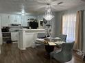 Dining room featuring modern chandelier, hardwood floors and an open transition to the kitchen area at 2408 Three Bars Dr, Snellville, GA 30078