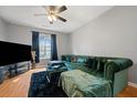 Living room featuring hardwood flooring and a large sofa with decorative pillows at 2322 Coach Way, Jonesboro, GA 30236