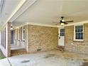 A spacious covered patio area featuring brick columns, ceiling fan, and a whitewashed ceiling at 3081 Oak Dr, Lawrenceville, GA 30044