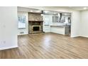 Open-concept living room featuring a brick fireplace, a ceiling fan, and hardwood floors at 3081 Oak Dr, Lawrenceville, GA 30044
