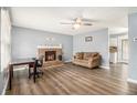 Cozy living room featuring a brick fireplace, neutral walls, ceiling fan, and new vinyl plank flooring at 620 Bell Se Rd, Conyers, GA 30094