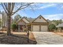 Charming home with stone accents, a two-car garage, and beautifully landscaped front yard under a clear sky at 918 Bridge Mill Ave, Canton, GA 30114