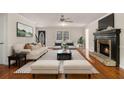 Bright living room featuring a fireplace, ceiling fan, hardwood floors, and a neutral color palette at 2984 Superior Dr, Dacula, GA 30019