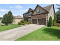 Attractive home with a two-car garage, landscaped front yard, and large driveway at 4249 Caveat Ct, Fairburn, GA 30213