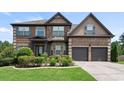 Charming two-story brick home with well-manicured lawn and attached two-car garage at 4249 Caveat Ct, Fairburn, GA 30213