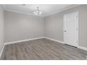Clean bedroom with neutral walls, wood-look flooring, white trim, and a modern chandelier at 765 Houston Mill Ne Rd # 7, Atlanta, GA 30329