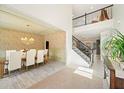 Open-concept dining room featuring stylish wallpaper and views of the staircase and upper level at 1439 Mill Pointe Ct, Lawrenceville, GA 30043