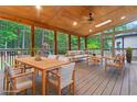 Outdoor covered patio with wood ceiling and skylight featuring dining and living furniture at 1439 Mill Pointe Ct, Lawrenceville, GA 30043