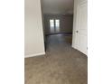 Spacious living room featuring neutral carpeting and double doors to outdoors at 2958 Parc Lorraine, Lithonia, GA 30038