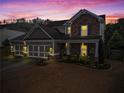 Charming two-story home featuring stone accents and a spacious three-car garage at twilight at 108 Summer Breeze Ln, Canton, GA 30114
