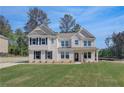 Charming two-story house showcasing white siding, black shutters, and a green lawn at 141 Frontier Way, Mcdonough, GA 30253