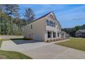Side view of a two-story home with a long driveway and an attached garage at 141 Frontier Way, Mcdonough, GA 30253