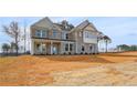 Elegant brick home boasts a spacious yard, complemented by detailed windows and architectural design at 141 Frontier Way, Mcdonough, GA 30253