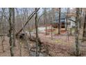 Scenic view of the house nestled among the trees with a stream in the foreground at 613 Rock Springs Pass, Dallas, GA 30157