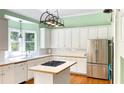 Bright kitchen featuring white cabinets, stainless steel appliances, and butcher block countertops at 10890 Regal Forest Dr, Suwanee, GA 30024