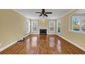 Spacious living room with hardwood floors, a brick fireplace, and ample natural light at 10890 Regal Forest Dr, Suwanee, GA 30024