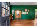 Elegant foyer with dark green walls, hardwood floors, vintage cabinet, and decorative wall art at 333 Drexel Ave, Decatur, GA 30030