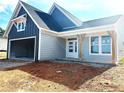 Charming home exterior with two-car garage, gray siding, and a covered front porch with wooden support beams at 33 Cambridge Ln, Dallas, GA 30157