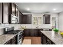 Well-equipped kitchen with dark wood cabinets and stainless steel appliances at 4358 White Spruce Aly, Doraville, GA 30360