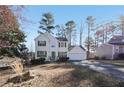 Inviting two-story home featuring green shutters, a paved driveway, and a serene, tree-lined setting at 1056 Shadow Lake Dr, Lithonia, GA 30058