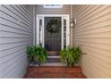 Inviting entryway with a dark front door, decorative wreath, and potted ferns at 2425 Pemberton Pt, Buford, GA 30519